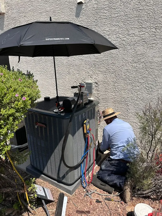 HVAC technician performing outdoor AC maintenance in Plain City