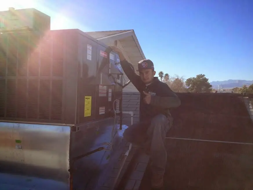 HVAC technician performing AC Tune-Up on a rooftop unit in Plain City